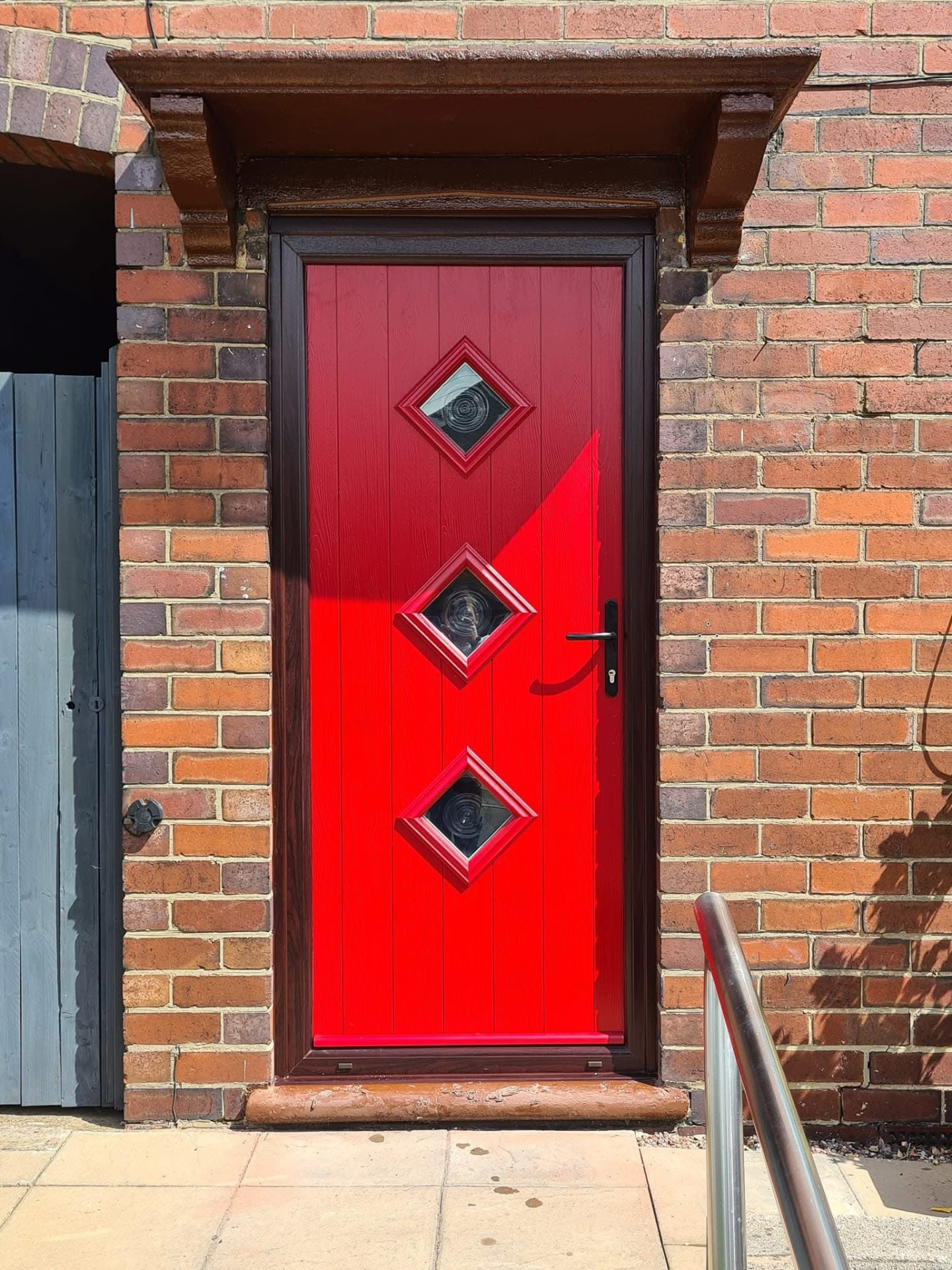 Vibrant red contemporary composite door with three square windows installed in Staffordshire