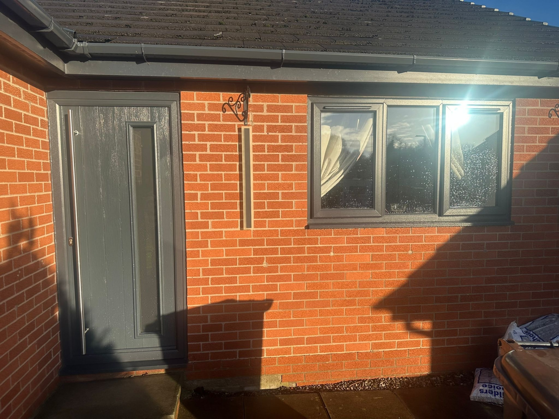Anthracite grey uPVC window and matching composite door on a red brick house