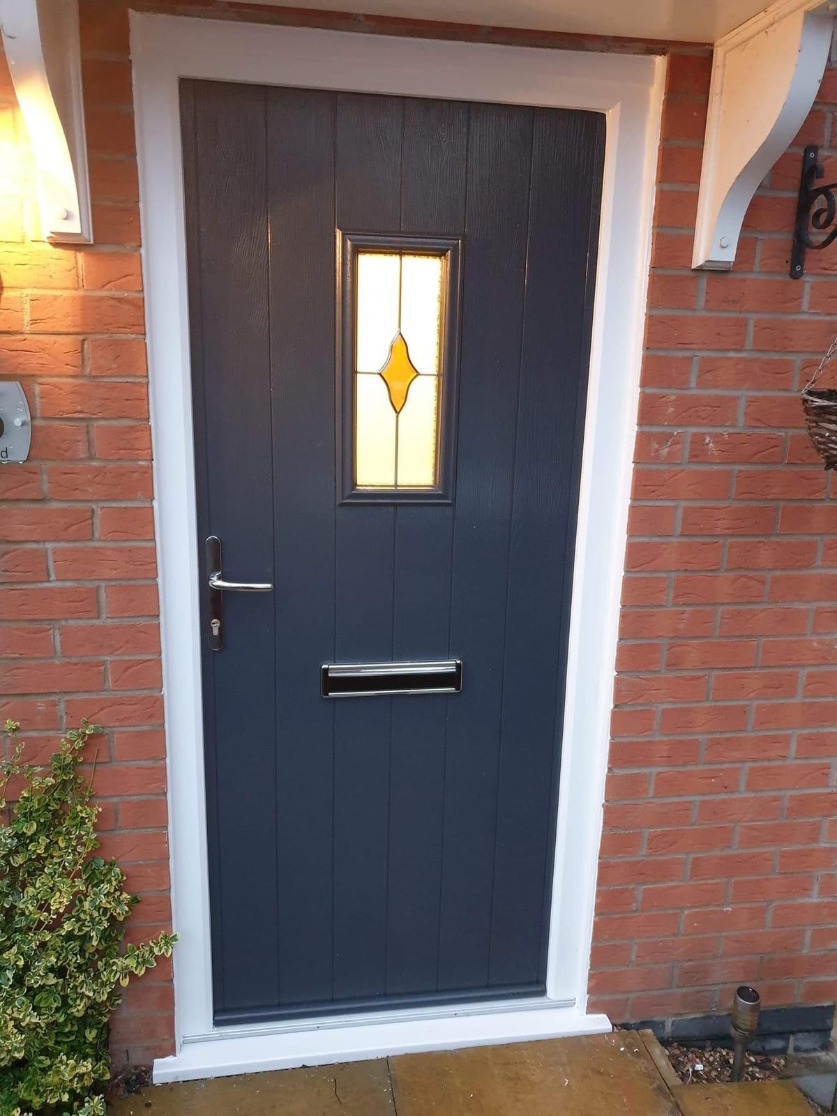 Composite front door with matching glazed side panel