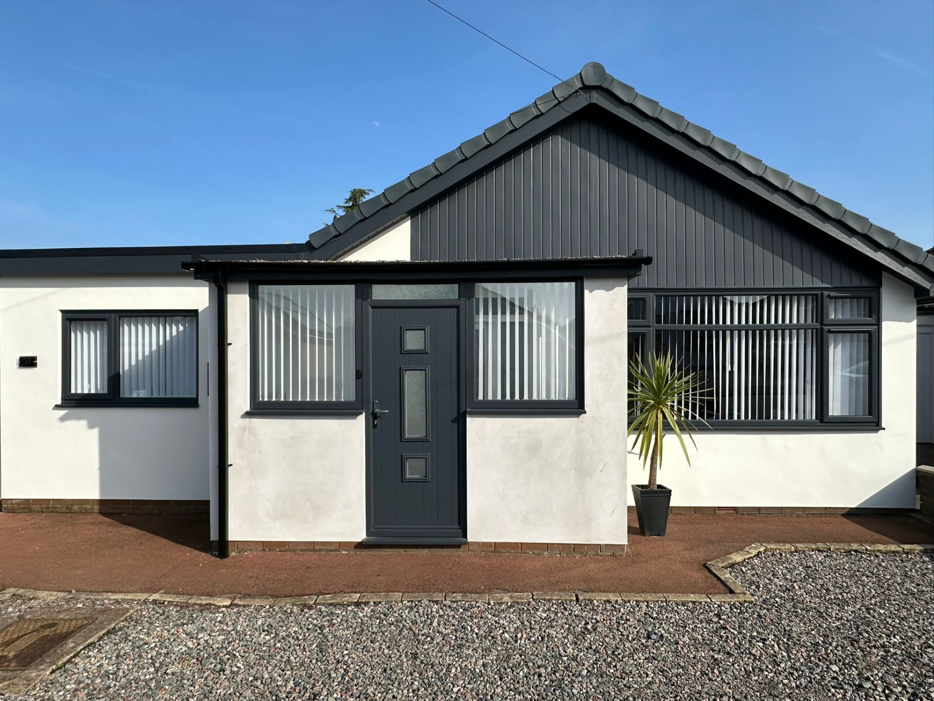 White rendered bungalow with newly glazed anthracite grey uPVC windows and door