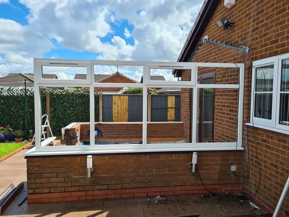 White uPVC conservatory frame under construction on a brick dwarf wall