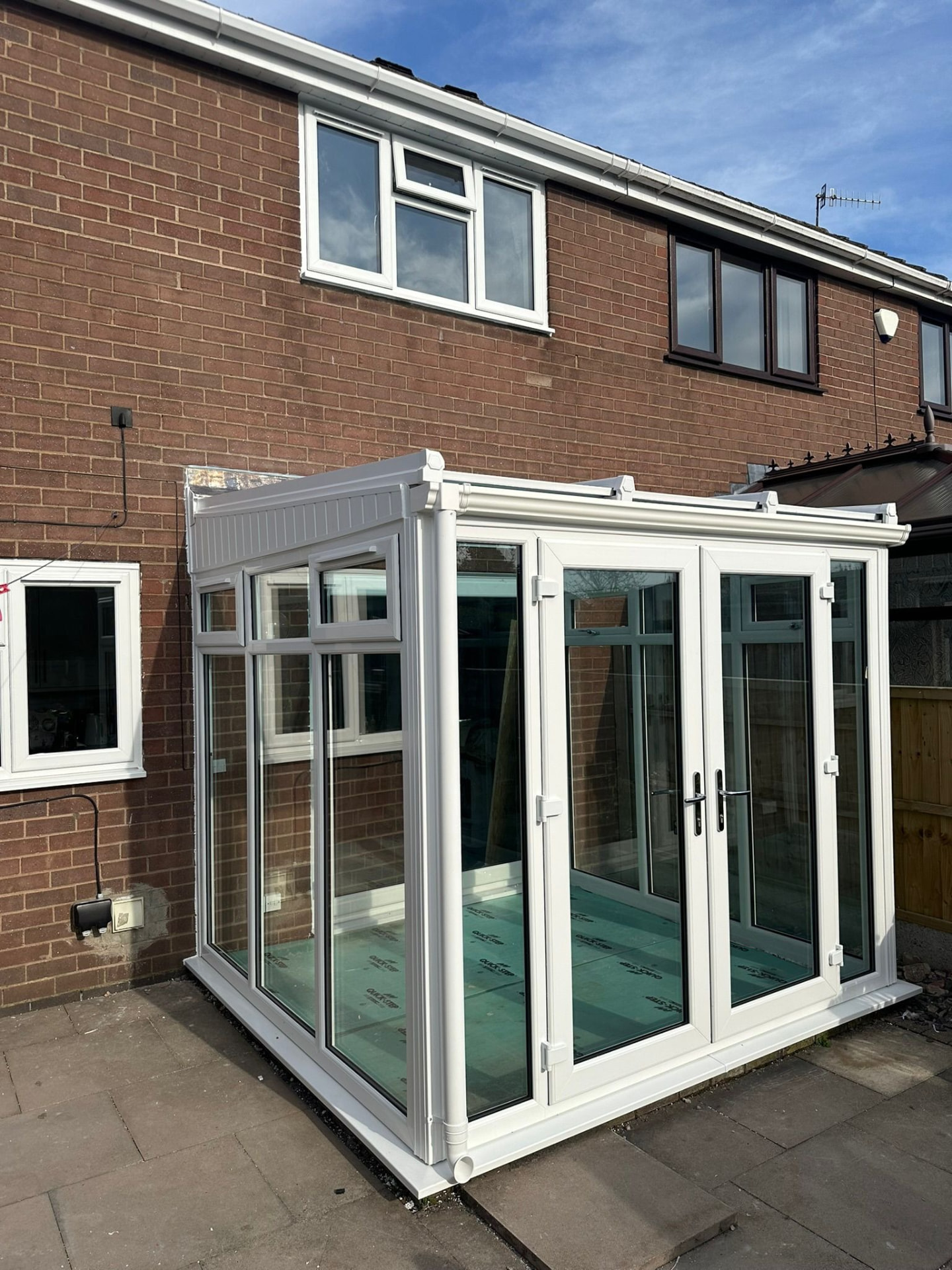Large white uPVC conservatory with full-height glass panels in Staffordshire
