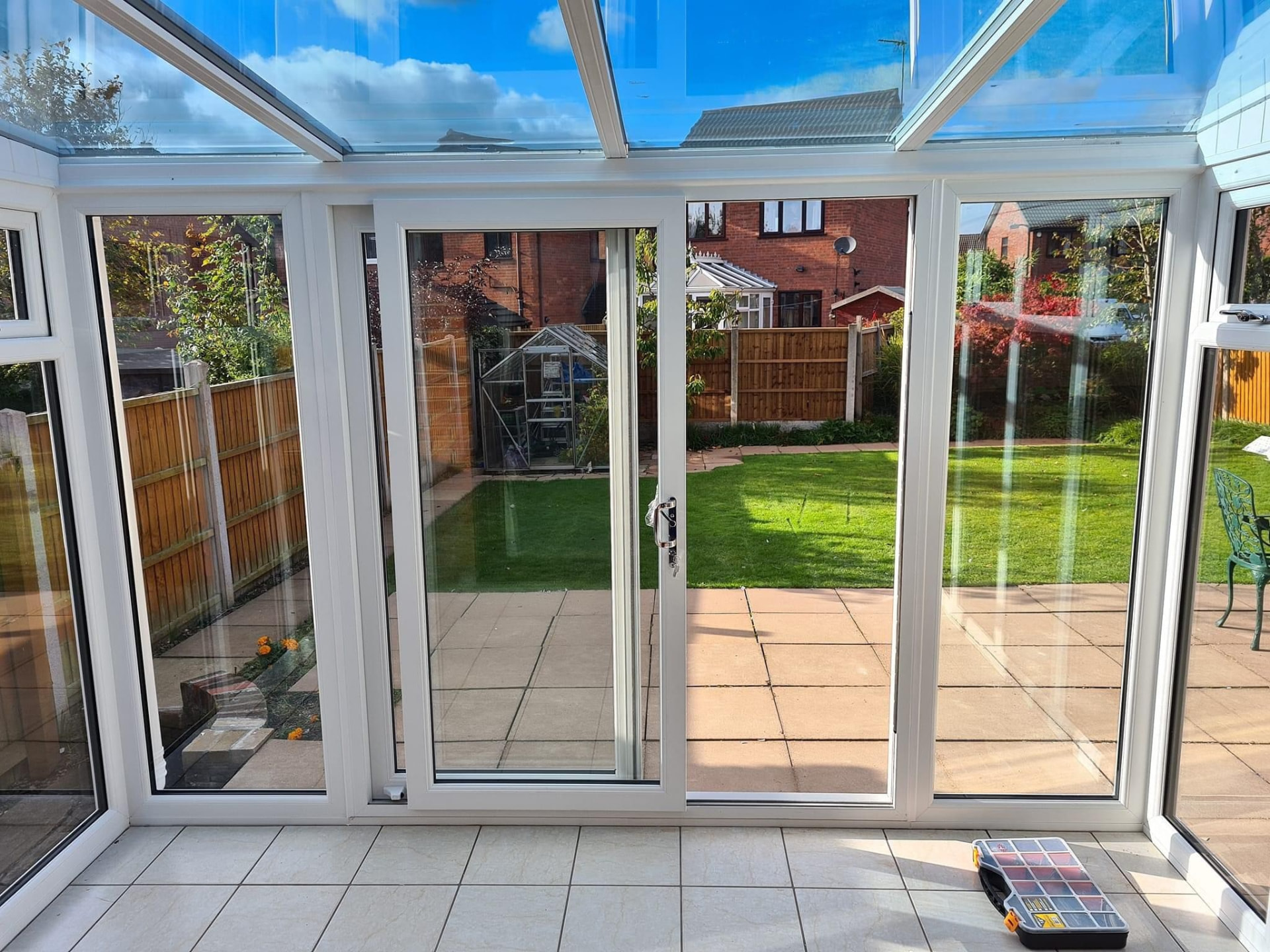 White uPVC sliding patio doors viewed from inside a conservatory looking out to the garden